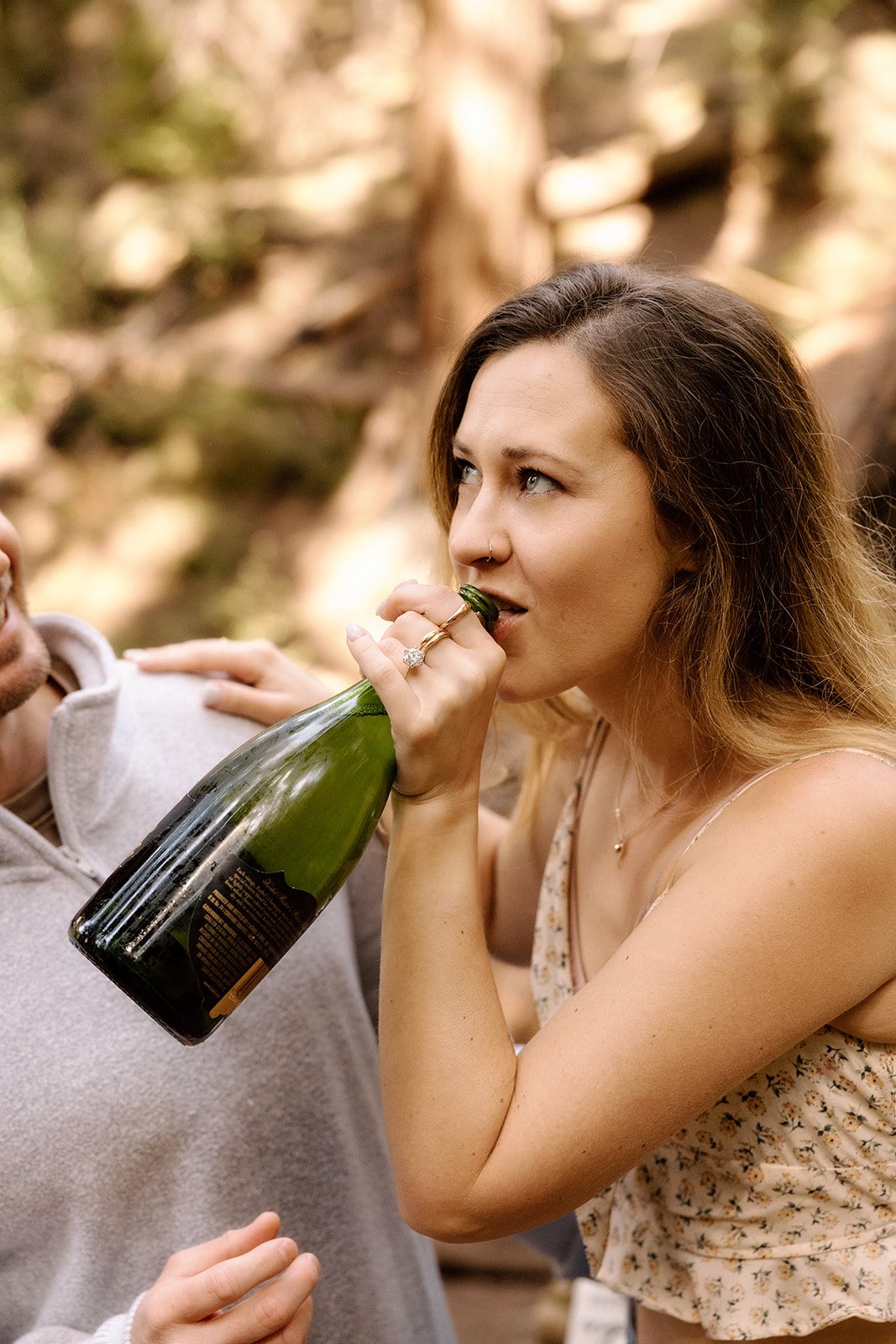 Aidan drinking champagne straight from the bottle in the redwoods